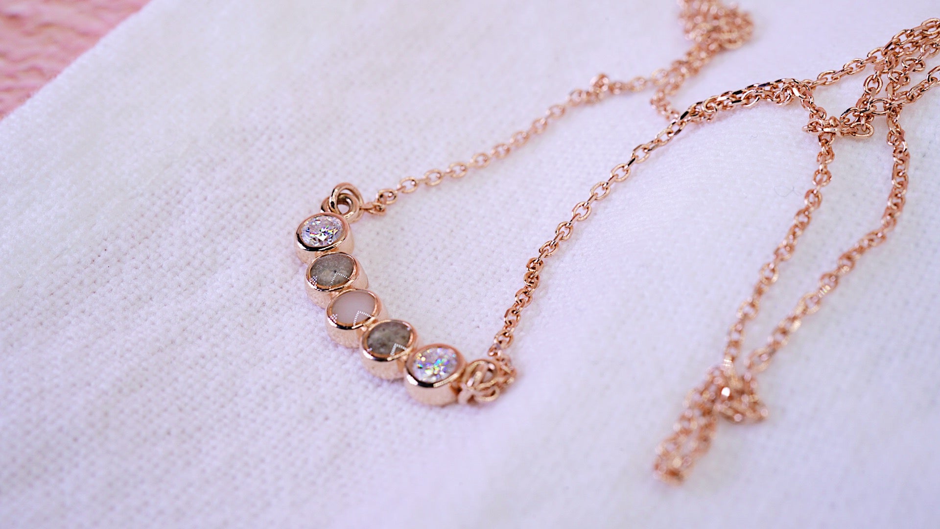 Solid gold necklace with 5 stones. 2 memorial cremation stones and one breastmilk jewellery stone in centre. One emerald each side 