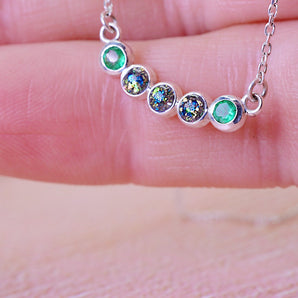 3 cremation ash stones with blue and green colour between two Emerald stones 