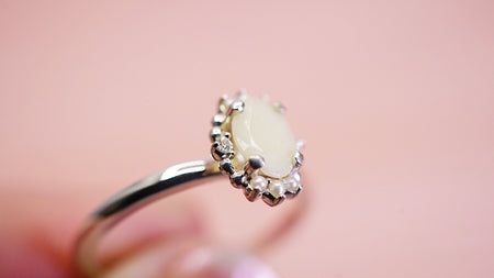 breastmilk stone surrounded by 6 pearls and 2 diamonds on a silver band
